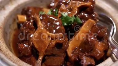 中餐厅小锅里炖牛尾和萝卜的动作